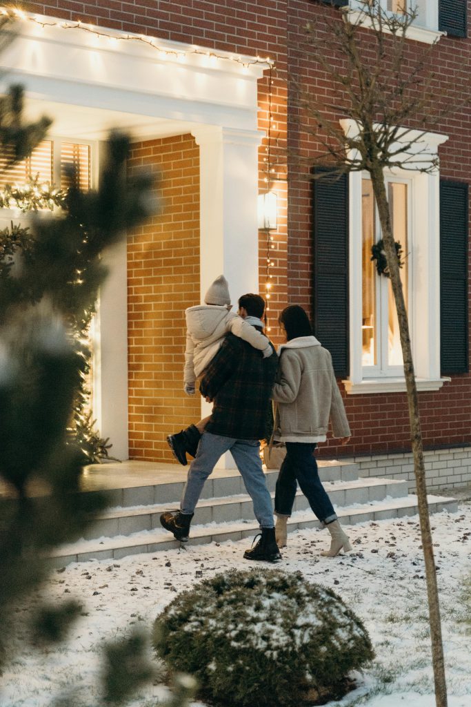 A family walks into their home on a snowy Christmas Eve, creating a warm holiday atmosphere.